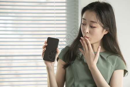 拿着手机惊讶的商务女性图片