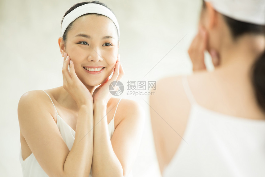 年轻女子照镜子护肤图片