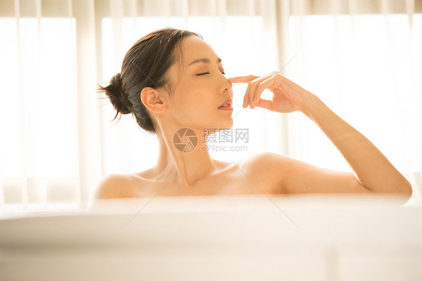 浴缸里泡澡的年轻女子图片