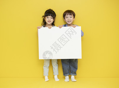 两个小孩举着画纸图片
