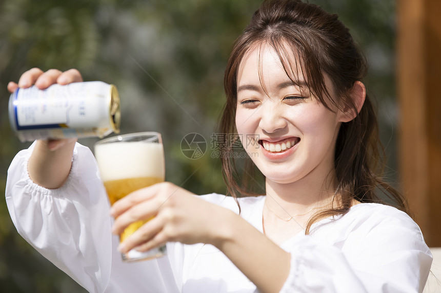 倒啤酒开心的年轻女子图片
