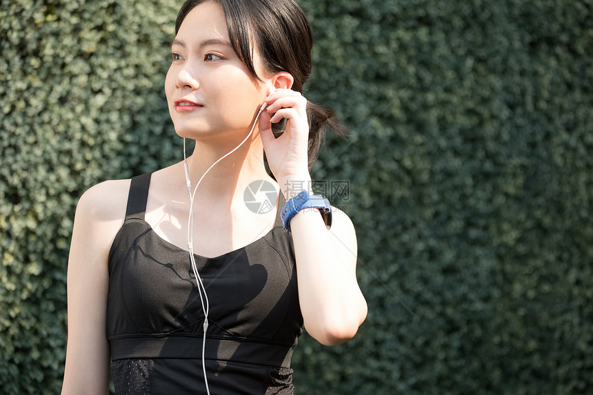 户外运动带耳机的年轻女子图片