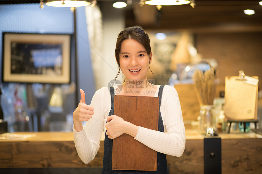 抱着托盘微笑的咖啡馆女店员形象图片