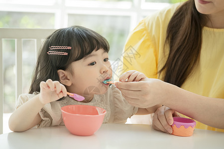母亲喂小女孩喝酸奶图片