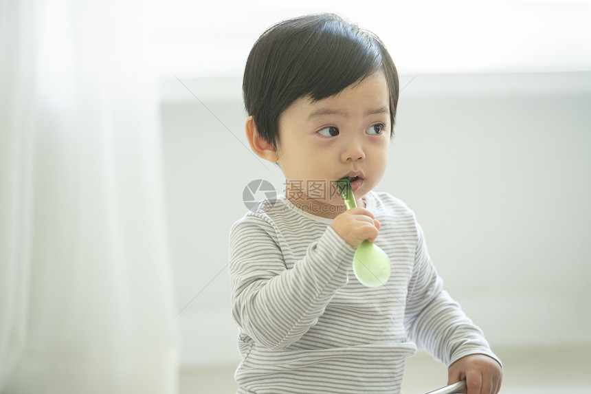 小朋友在客厅地毯上边吃饭边玩耍图片