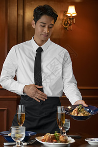 为顾客上菜的男服务员图片