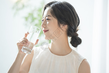 拿着水杯喝水的青年女子图片