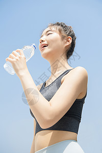户外喝水休息的运动女青年图片