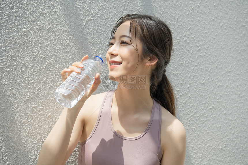 喝水休息的运动女青年图片
