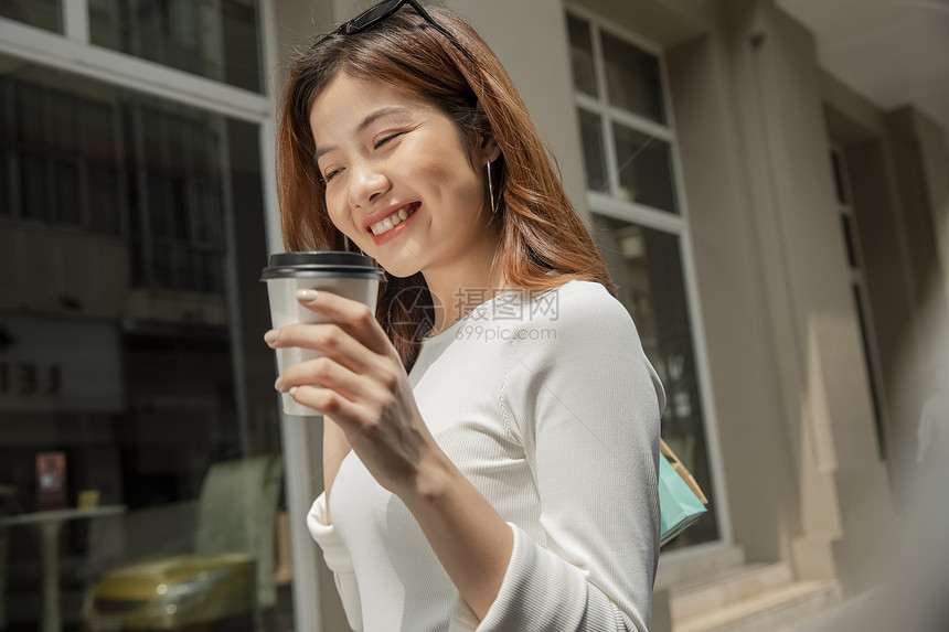 拿着咖啡愉快的青年女子图片