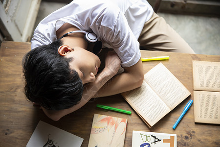 青年男子趴在桌子上小憩图片