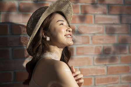 戴着遮阳草帽开心的度假美女图片