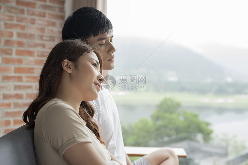 站在阳台放松的年轻情侣图片