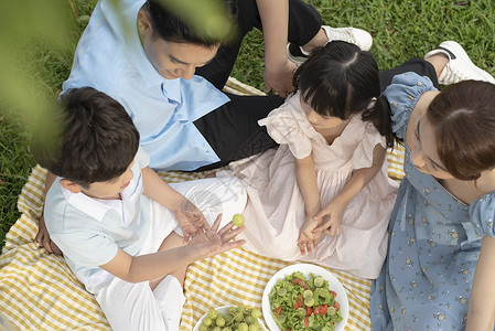 户外草坪野餐郊游的一家人图片