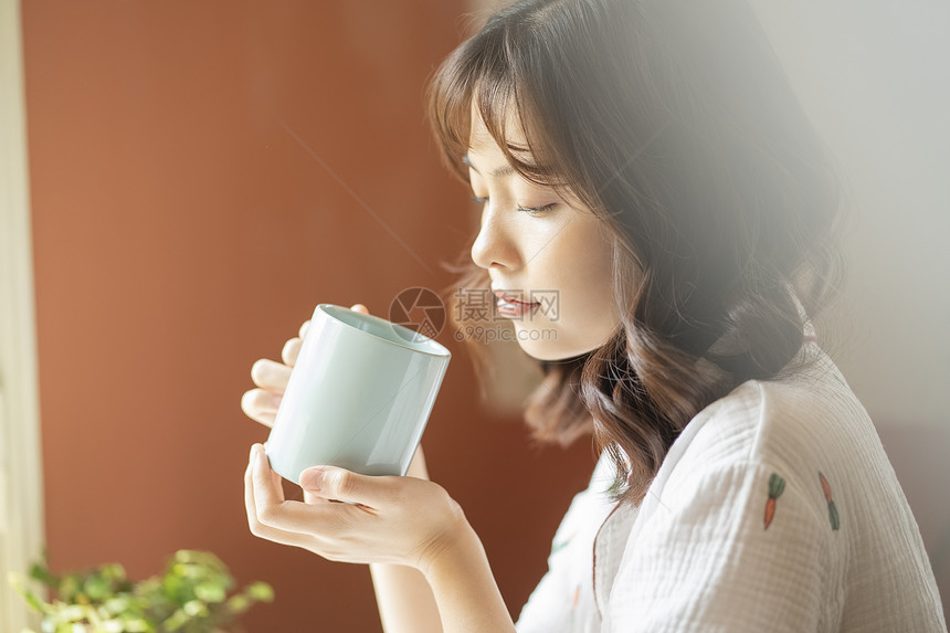 早晨居家喝水的年轻女子图片