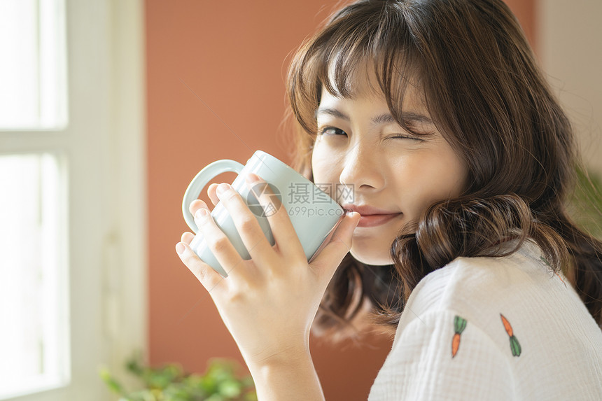 年轻女子捧着咖啡微笑图片