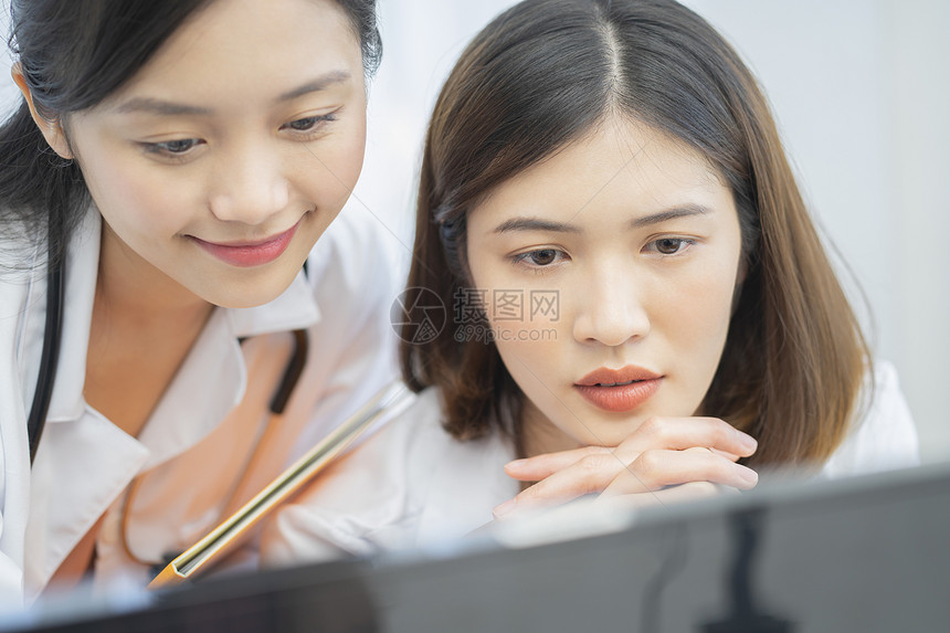 年轻女医生看着电脑思考讨论图片