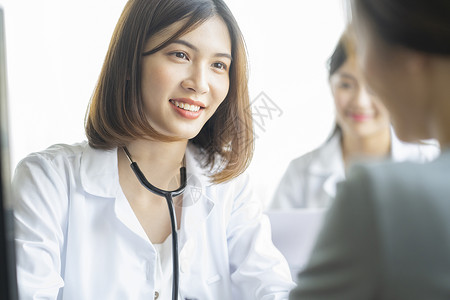 年轻女医生微笑为病人看病图片