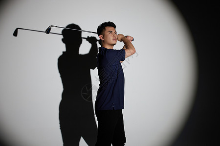 聚光灯下的男性打高尔夫球图片