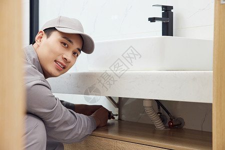 维修工人维修洗手盆下水管形象工具高清图片素材