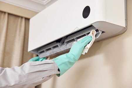 维修工人使用抹布清洁空调机特写高清图片