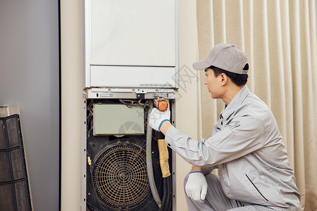 男性维修工人上门检修立式空调机图片素材