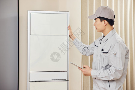 男性维修工人上门检测立式空调图片素材
