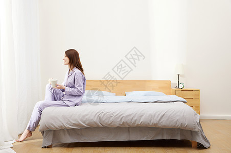国际茶早上起床坐在床边的精致女生背景