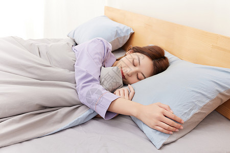 躺在床上睡觉的年轻女性舒适高清图片素材