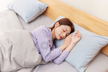 躺在床上睡觉的年轻女性休息高清图片素材