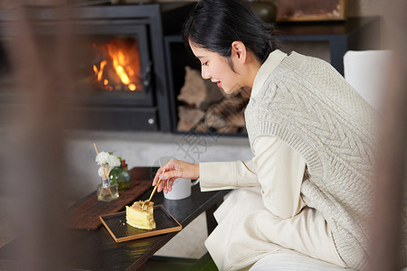 美女在吃蛋糕在火炉边取暖吃点心的女性背景