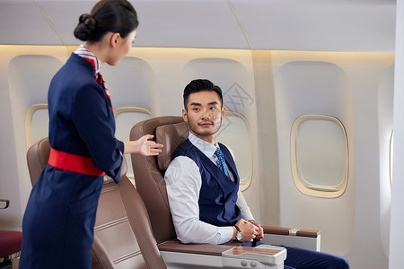 飞机商务舱空姐为乘客服务图片