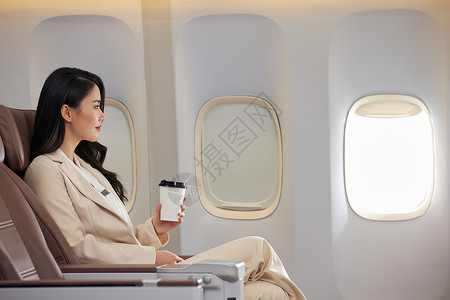 年轻女性飞机上喝咖啡高清图片