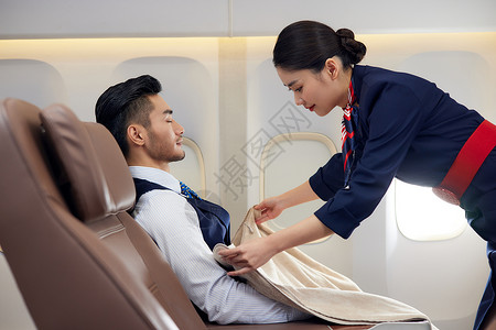飞机睡觉空姐为睡觉的乘客盖上毛毯背景