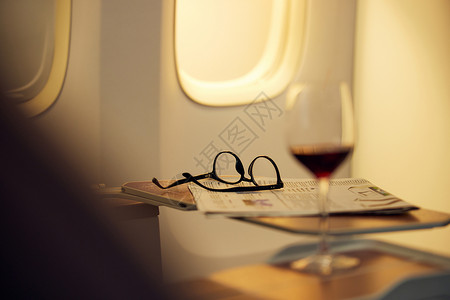 飞机商务车座椅上的报纸和眼镜背景图片