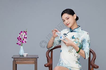 年轻旗袍女性喝茶背景图片