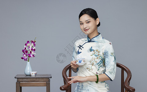 年轻旗袍女性品茶图片