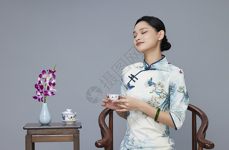 年轻旗袍女性端坐喝茶图片