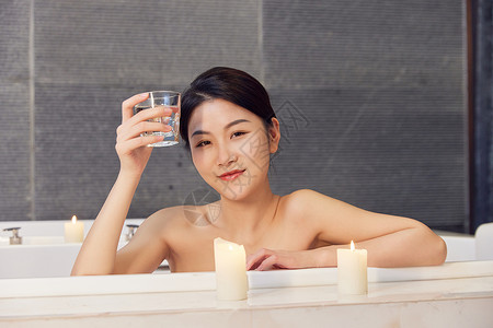 浴缸泡澡的美女手拿杯子喝水高清图片