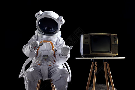 宇航员坐在椅子上边上放着电视机图片