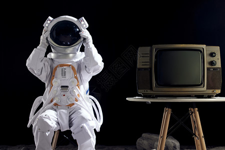 坐在电视机旁的宇航员背景图片