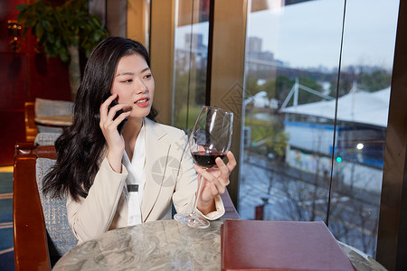商务酒店女性喝红酒打电话图片
