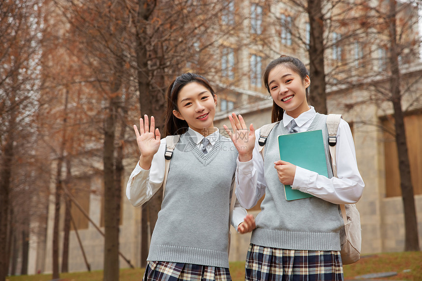 校园美女学生抱着书本打招呼图片