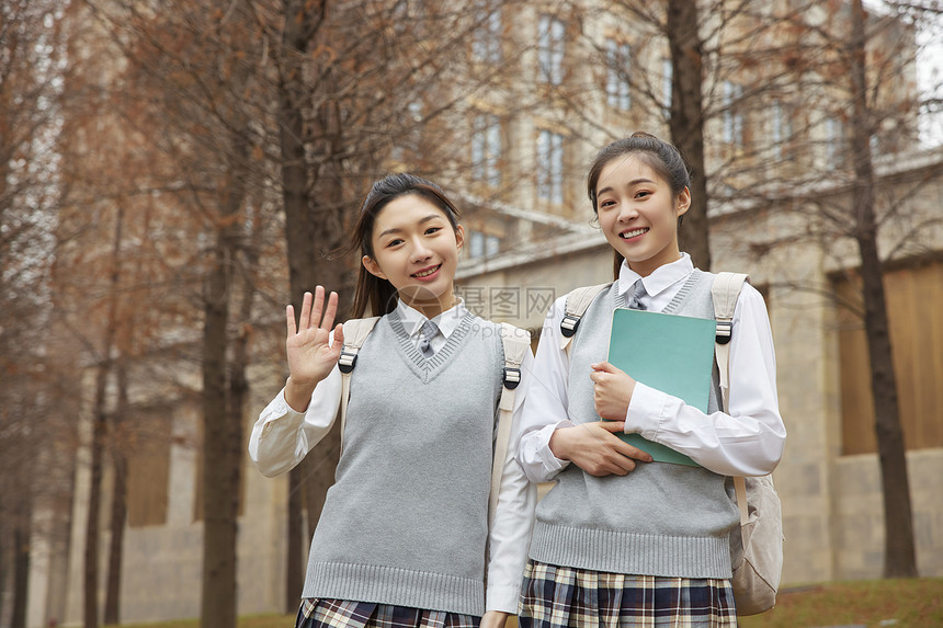 校园美女学生抱着书本打招呼图片