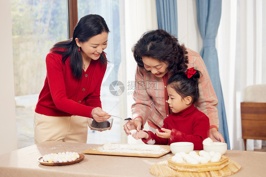 奶奶和妈妈指导小女孩包汤圆图片