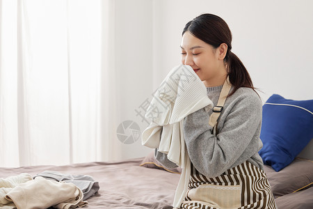 居家整理衣物的青年女性图片