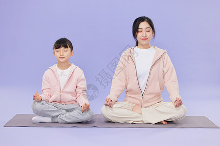 母女坐在瑜伽垫上冥想高清图片