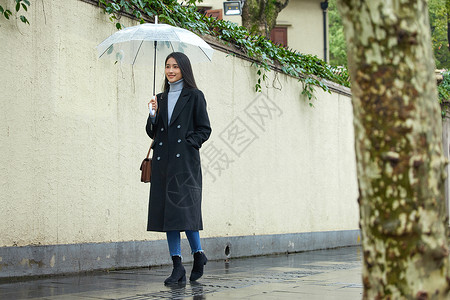下雨天撑伞行走的女性背景图片