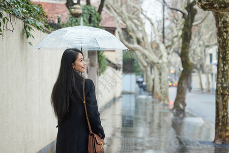 下雨天撑伞走在路边的女性街拍高清图片素材