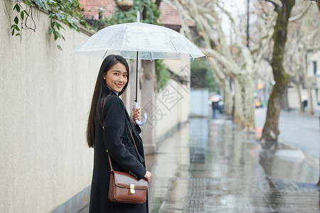 打着雨伞的女性回头背景图片